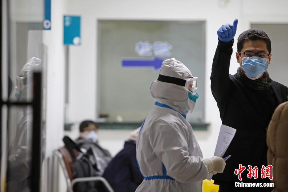 浦東新区人民病院の医療従事者に対し、親指を立てるジェスチャーで「いいね！」の気持ちを示す浦東空港にから入国した発熱者（撮影?殷立勤）。